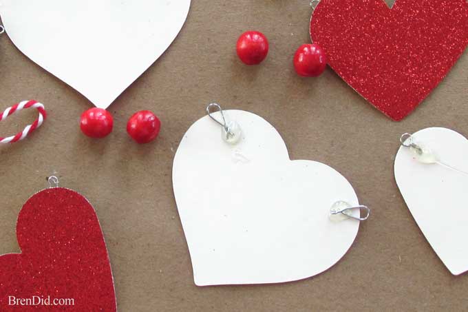 Get ready for Valentine's Day parties and events with this glitter garland inspired by Pottery Barn Kids. This easy Knock Off DIY craft uses glitter cardstock, some twine, and wooden beads to make a charming Valentine's Day banner for under $3.