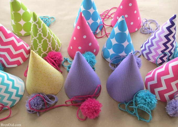 Fabric covered party hats are an easy craft and an affordable way to take your birthday party decor to the next level. With a little patterned fabric, glue, yarn and card stock you can turn a common party decoration into something extraordinary.