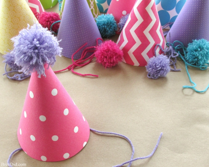 Fabric covered party hats are an easy craft and an affordable way to take your birthday party decor to the next level. With a little patterned fabric, glue, yarn and card stock you can turn a common party decoration into something extraordinary.