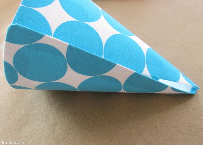 Fabric covered party hats are an easy craft and an affordable way to take your birthday party decor to the next level. With a little patterned fabric, glue, yarn and card stock you can turn a common party decoration into something extraordinary.