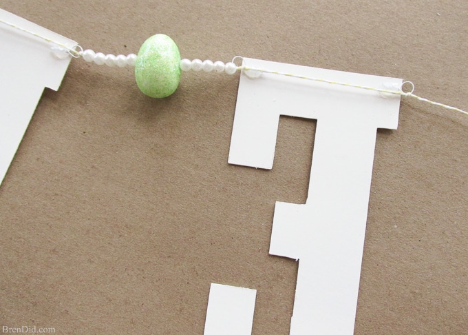 Pottery Barn Kids inspired glitter Happy Easter banner made from cardstock, twine, beads, and glitter styrofoam eggs. Takes only a few minutes to assemble and cost $4.00! Add a special touch to your Easter décor.