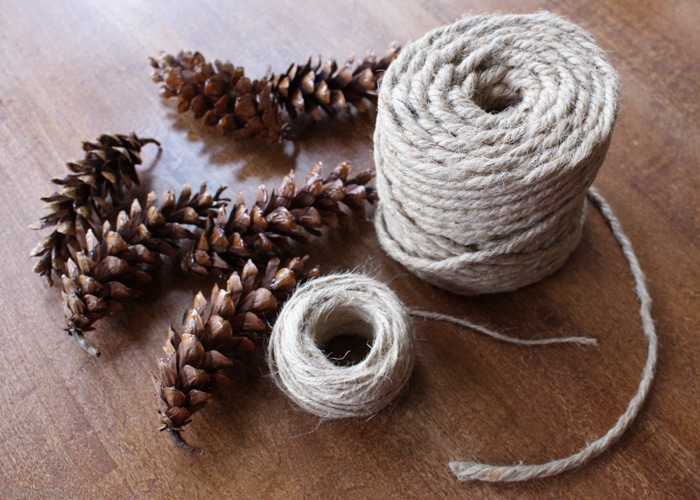 Learn how to make an pine cone garland for a touch of woodland style. This easy tutorial shows you how to create your own easy pine cone garland for less than $1.30 per foot. Eco-friendly.