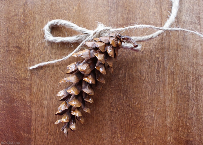 Learn how to make an pine cone garland for a touch of woodland style. This easy tutorial shows you how to create your own easy pine cone garland for less than $1.30 per foot. Eco-friendly.