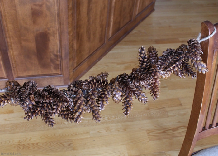 Learn how to make an pine cone garland for a touch of woodland style. This easy tutorial shows you how to create your own easy pine cone garland for less than $1.30 per foot. Eco-friendly.