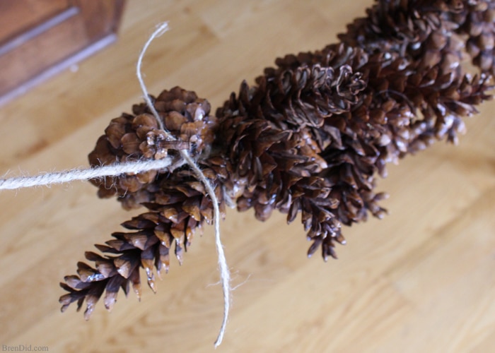 Learn how to make an pine cone garland for a touch of woodland style. This easy tutorial shows you how to create your own easy pine cone garland for less than $1.30 per foot. Eco-friendly.