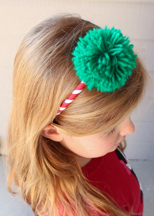 Learn how to make a Pom Pom Headband. Easy craft tutorial. These fun and trendy pom pom headbands are an adorable addition to any outfit and cost less than $2.25! DIY