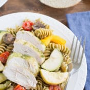Chicken Pesto Pasta Easy Crockpot Recipe: This throw & go crock pot recipe features basil pesto, chicken, roast vegetable, and chicken. Serve it with pasta for a healthy and tasty dinner that takes just minutes to prepare.