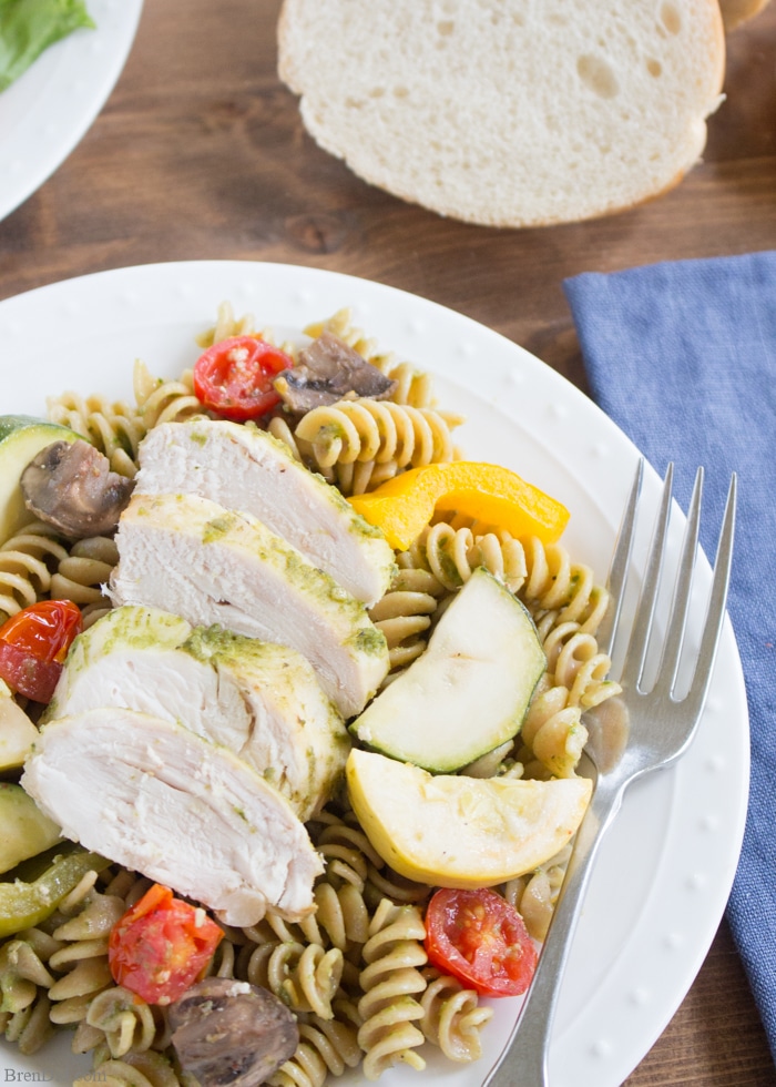 Chicken Pesto Pasta Easy Crockpot Recipe: This throw & go crock pot recipe features basil pesto, chicken, roast vegetable, and chicken. Serve it with pasta for a healthy and tasty dinner that takes just minutes to prepare. 