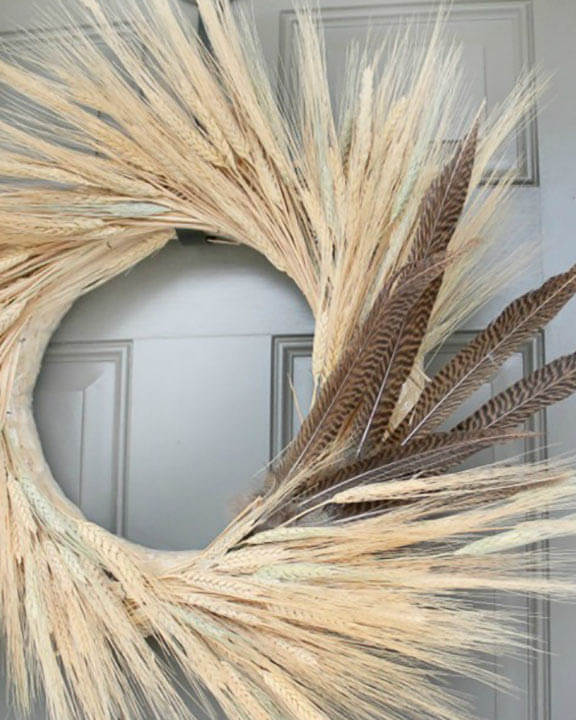 fall wreath made from wheat and feathers