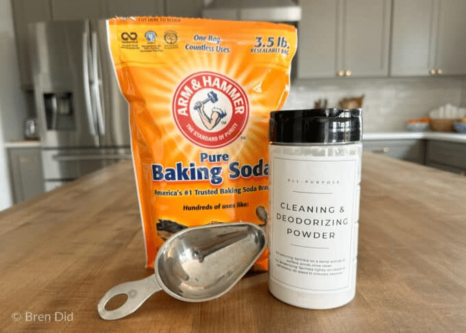 Carpet powder in shaker bottle with bag of baking soda and measuring cup.